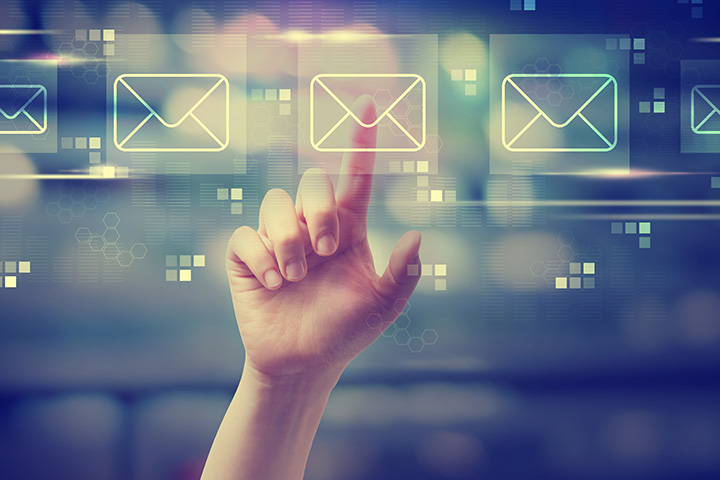 Hand pointing to a hologram of an email envelope icon