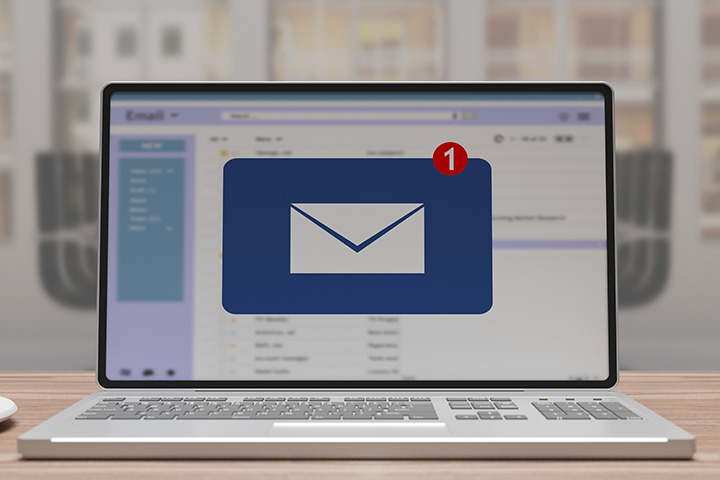 Laptop with email icon and notification bubble showing an unopened email