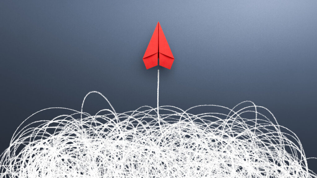 Image of a red paper airplane with a white chalk line and scribbles below it