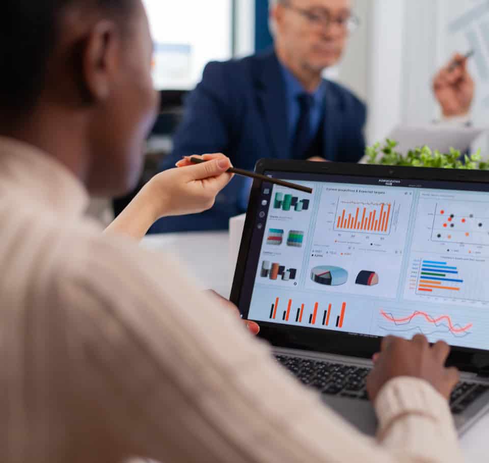 Multi-ethnic business team sitting at table in office center speaking about project during meeting in broadroom. Businesswoman discussing ideas with colleagues about financial strategy for new start up company working in brainstorming office.